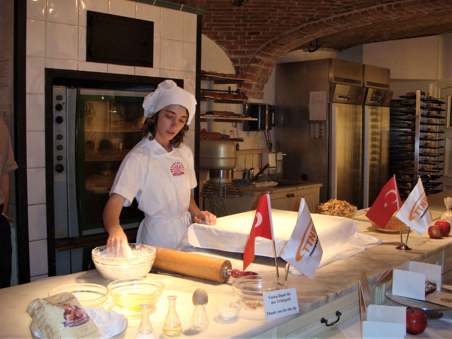 Bu aşçı kız, Avusturya'nın milli tatlısı Apfelstrudel'in, yani Elmalı Turta'nın yapımını uygulamalı olarak gösteriyor